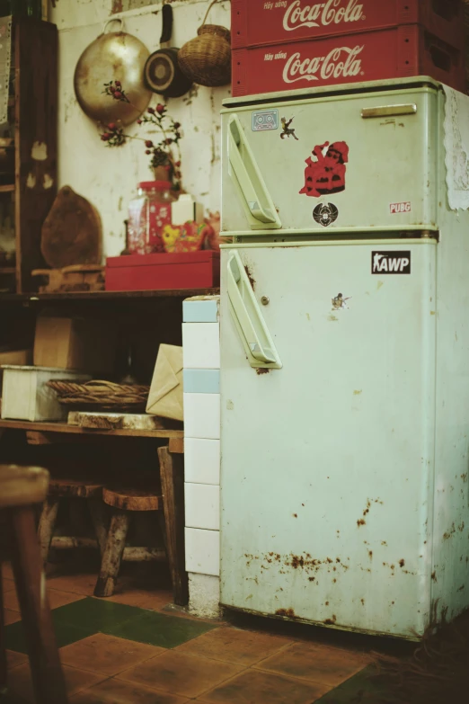 an old, rusty, old coca cola machine sitting next to boxes of old soda