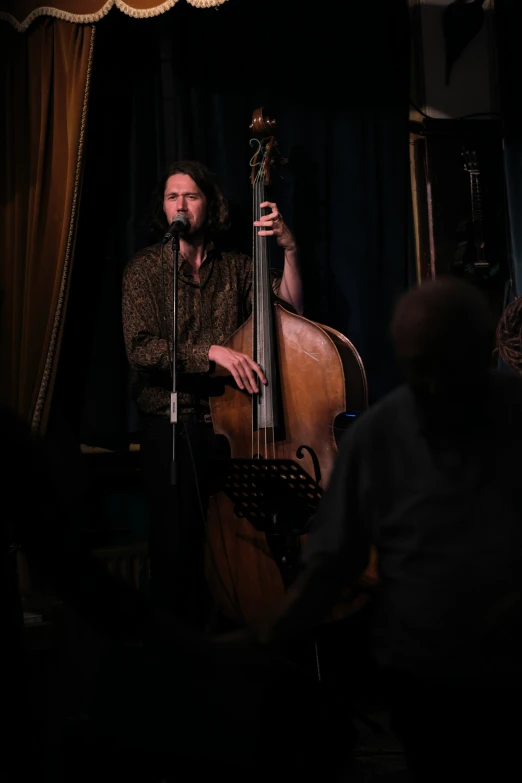 an old man with a beard is playing a bass