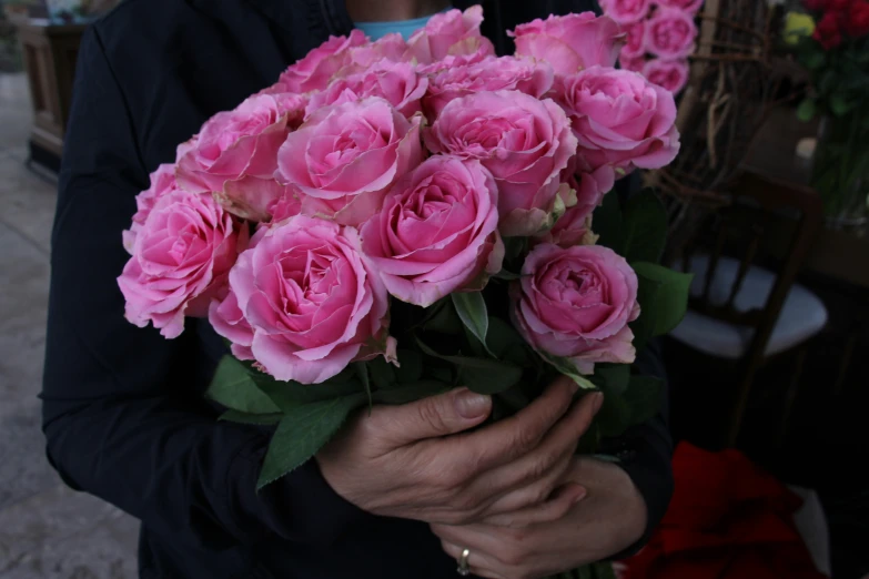 a person holding a bunch of flowers outside