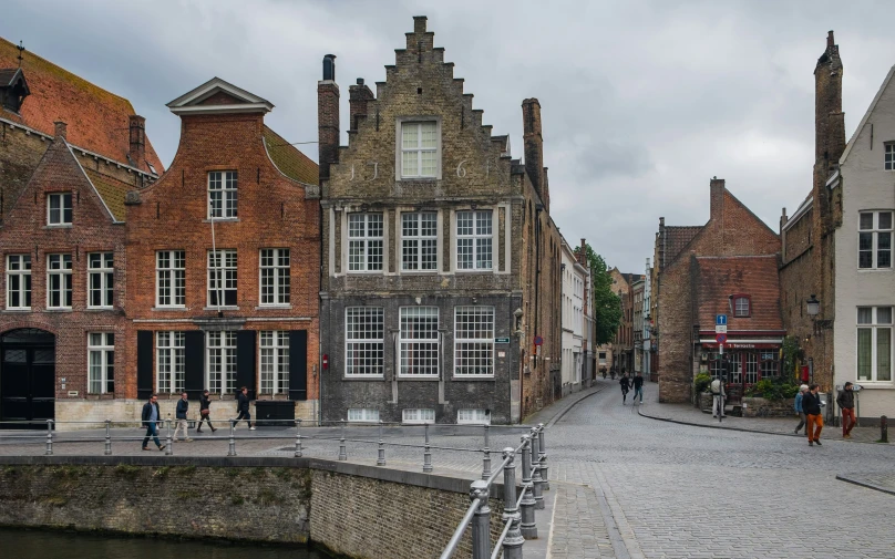 a cobblestone street with old brick buildings and people walking