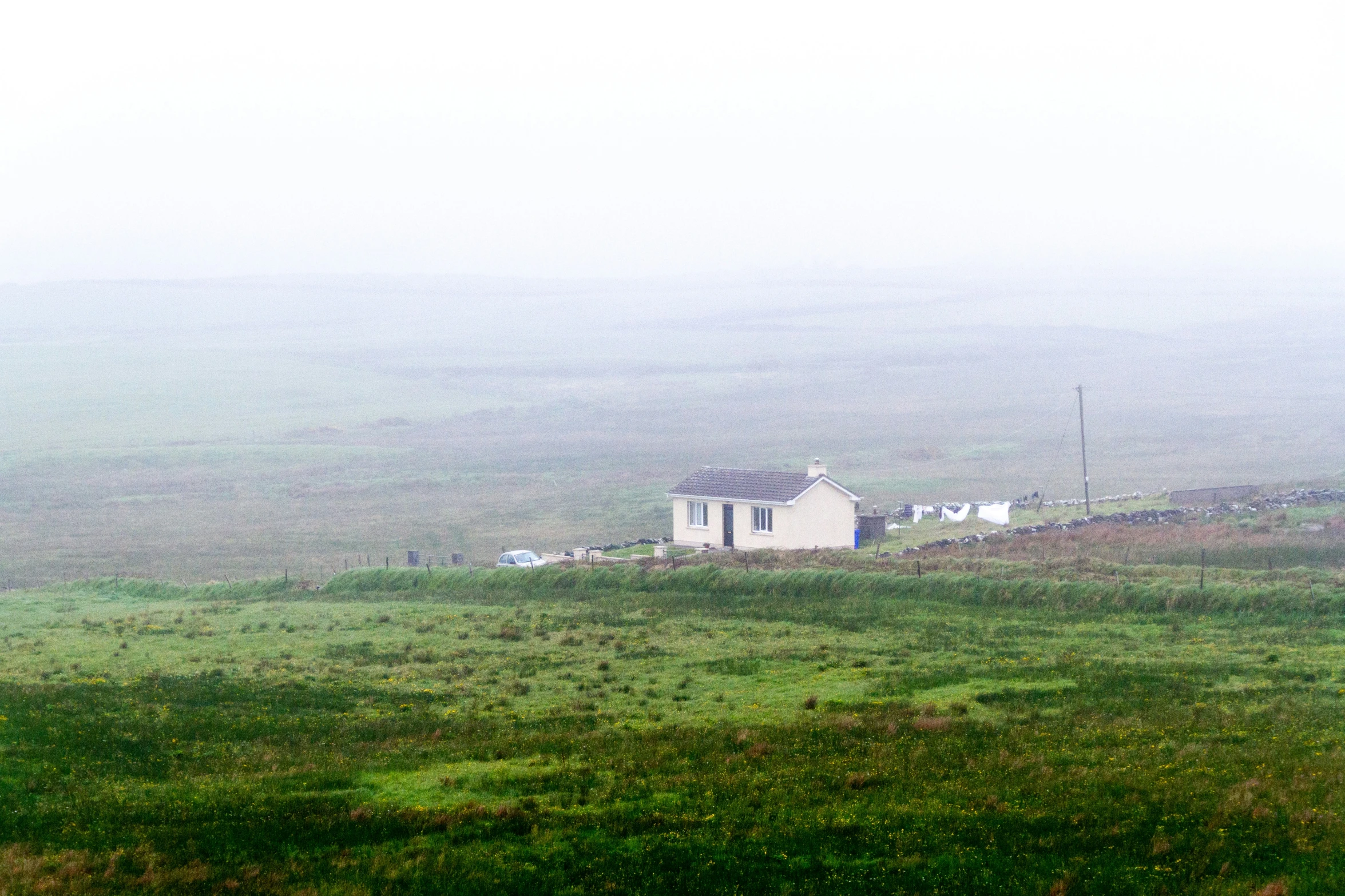 a house in the fog on a hilly area