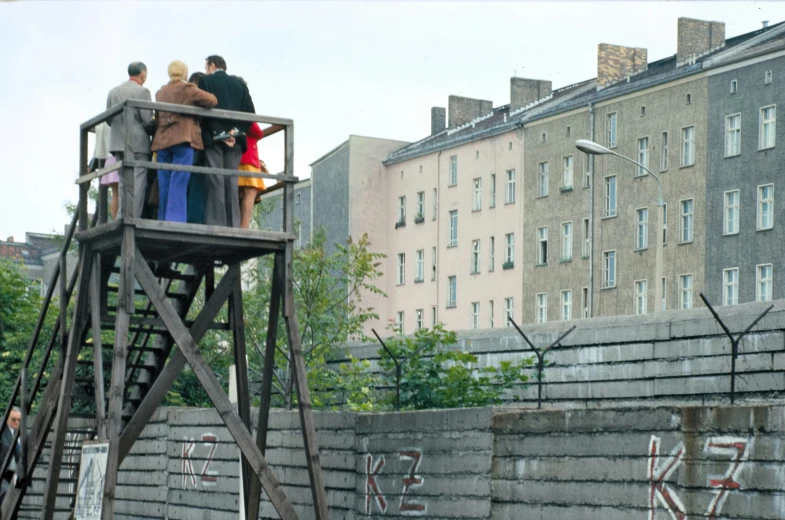 a group of people standing on a wooden tower