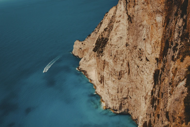 a boat is floating along the water in the blue ocean