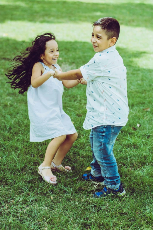 a  and girl shaking hands in the grass