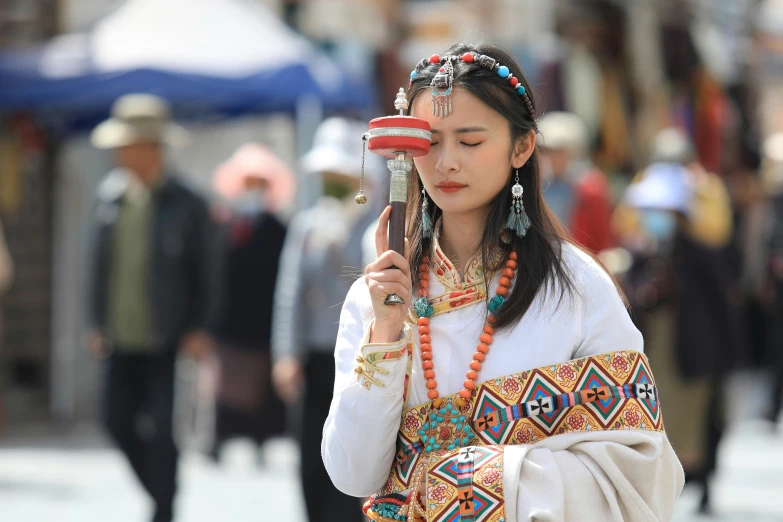 an asian woman wearing head jewelry walking down the street