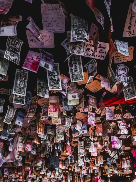 many money notes hang from hooks for display