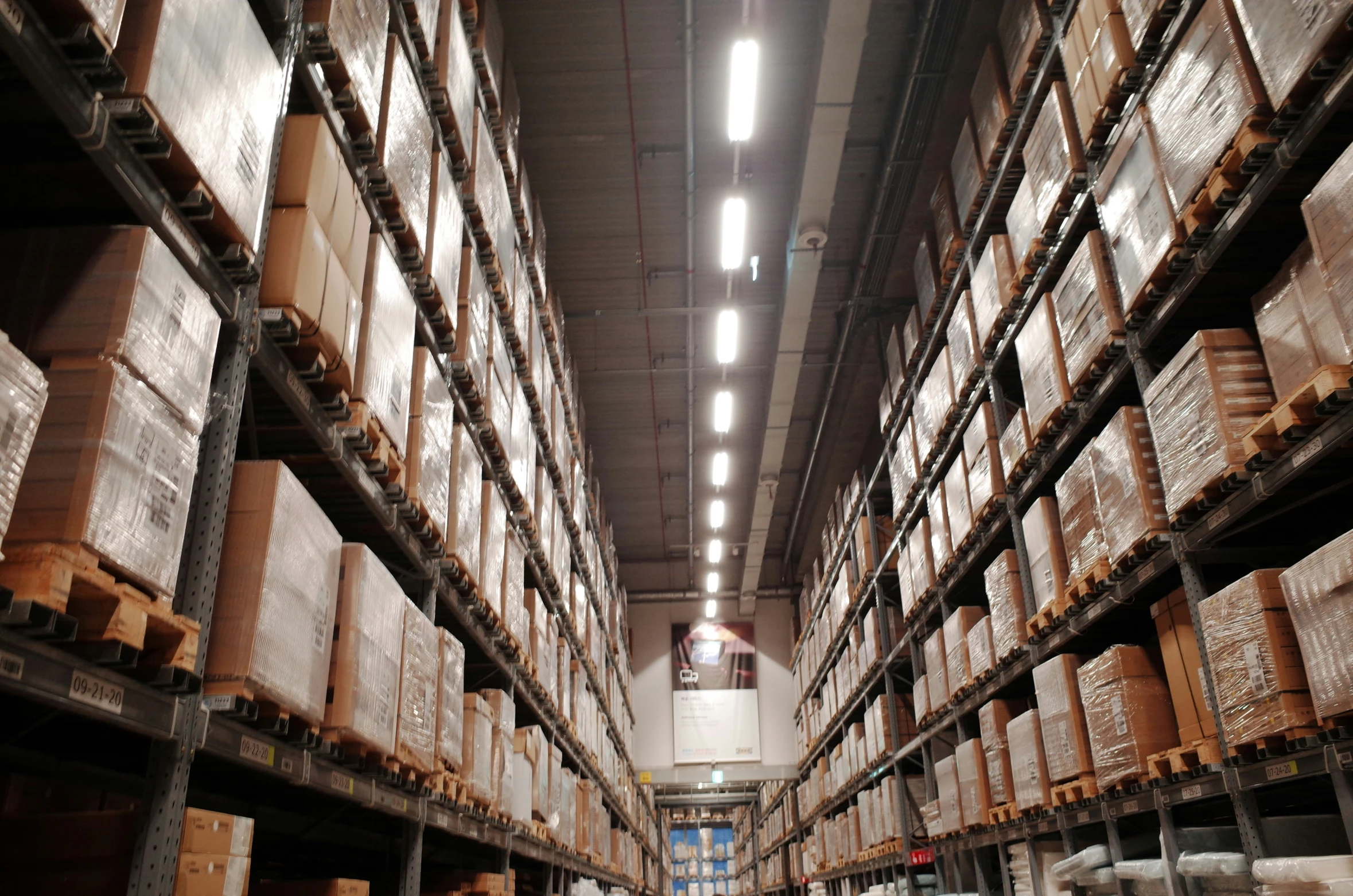 a large amount of boxes stacked on one long shelf