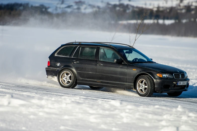 a car driving through the snow near trees