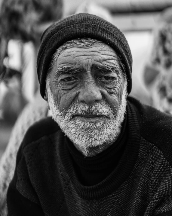 a black and white pograph of a man in a beanie