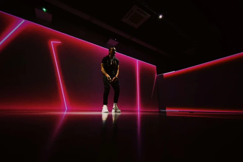 man in front of an iridescent wall with pink lights