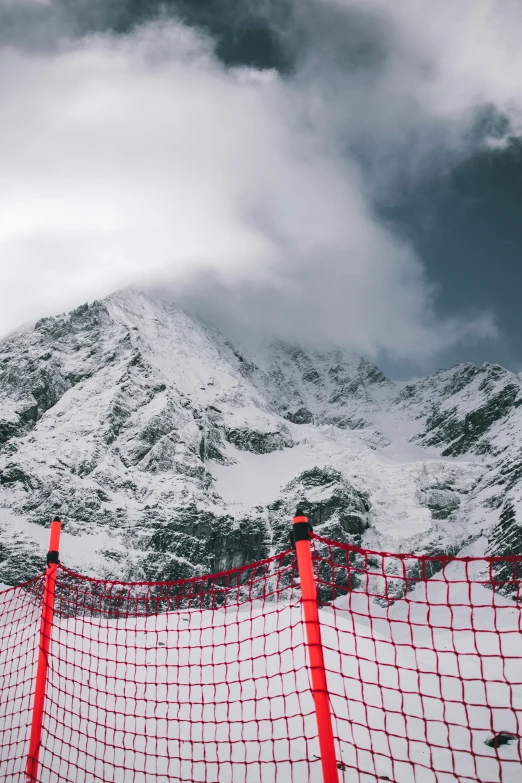 a red fence on a snow covered mountain