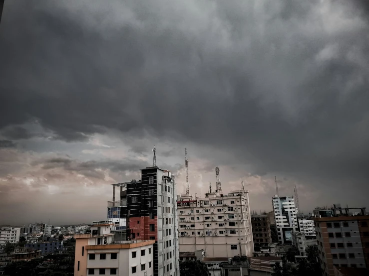 some buildings with a storm in the background