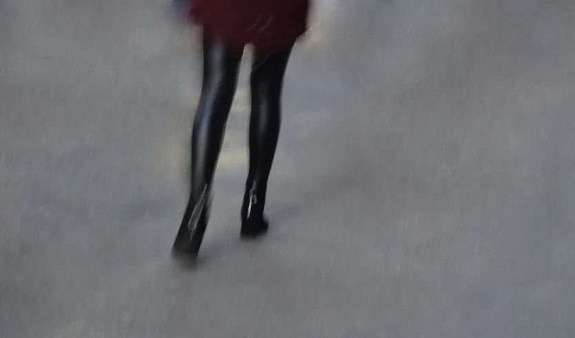 a blurry po of a woman walking down the street with an umbrella