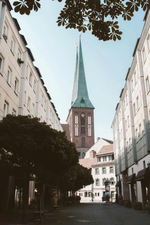 a clock tower towering over the town next to a road