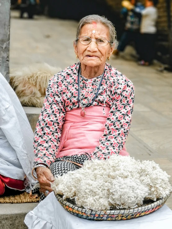 a woman in pink sitting by a pile of pillows