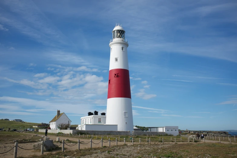 a red and white lighthouse in front of a building