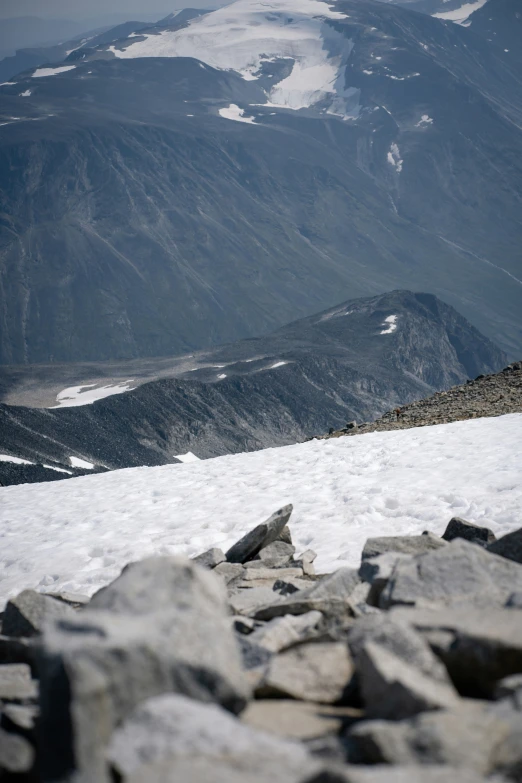 a person standing in the snow near some rocks