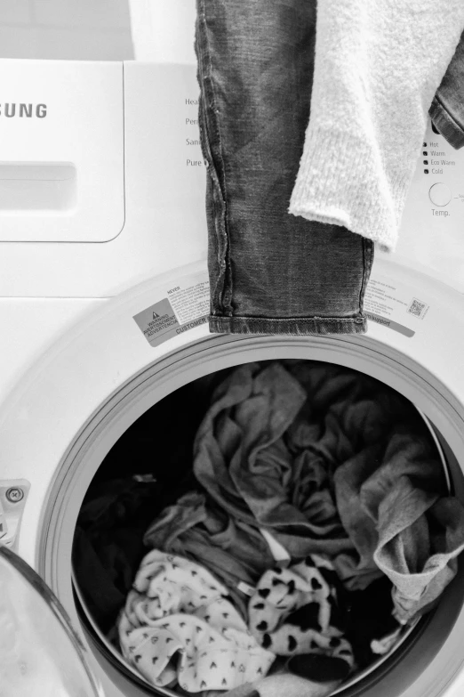 a washing machine with laundry towels hanging out