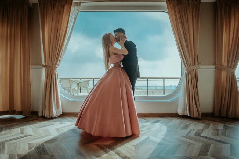 the man and woman are hugging in the window of their suite