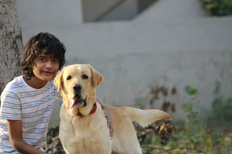 the  is posing with her yellow dog