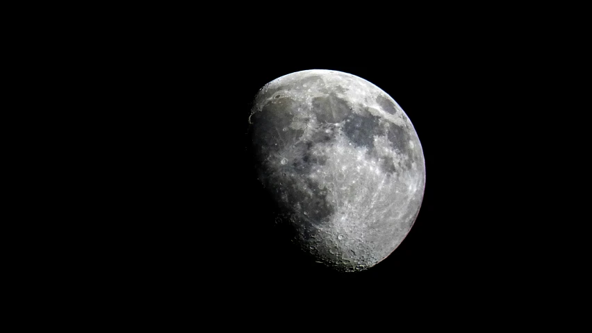 a moon with its shadow against the night sky