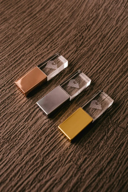 three small rectangular objects sitting on top of a brown table