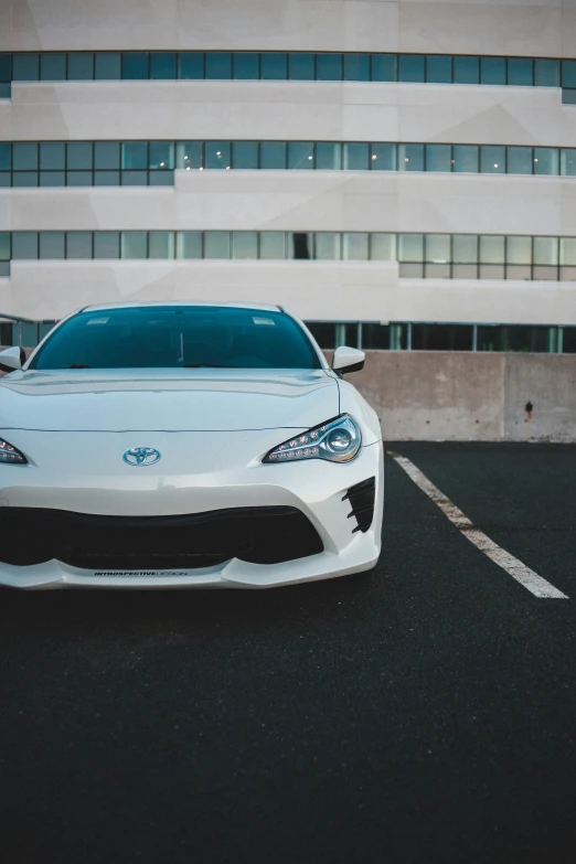 a white sports car is parked in front of a building