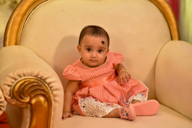 a small baby sitting on a chair in a room