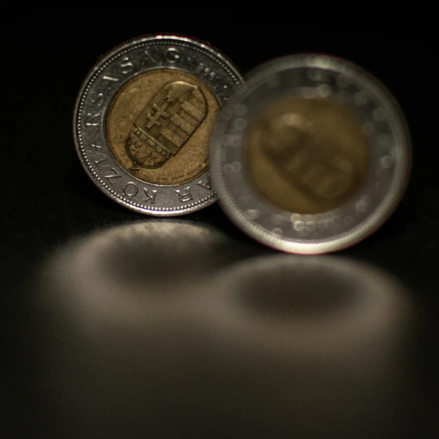 one euro coin placed upside down on a black surface