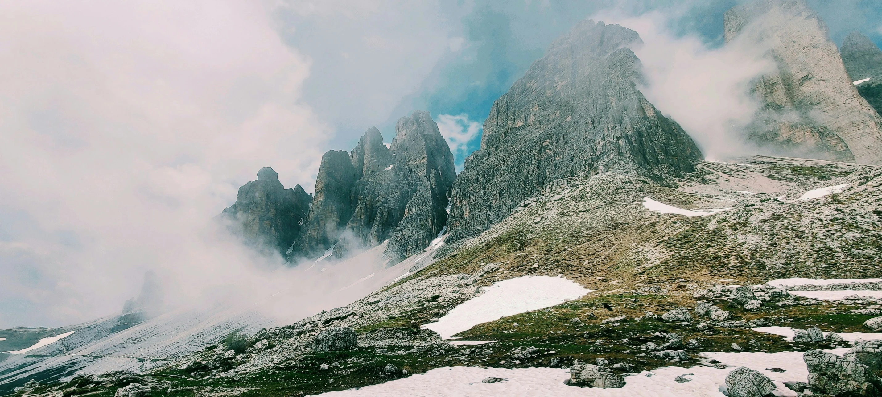 some mountains covered in snow and clouds