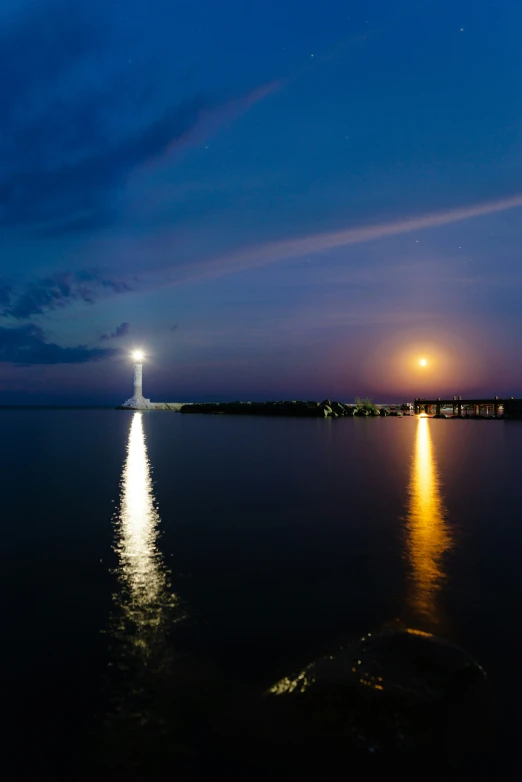 a full moon sitting above a body of water