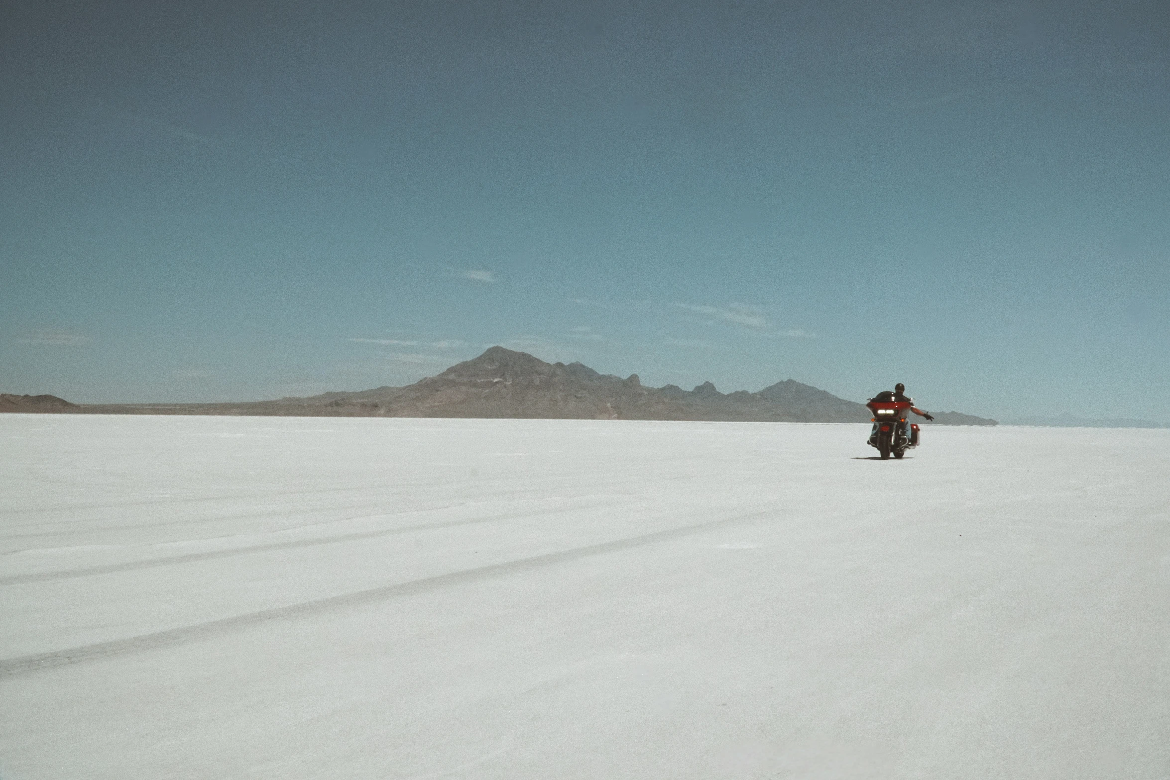 a person rides a motorcycle on the snowy surface