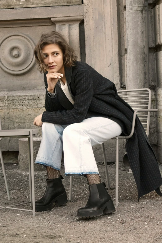 a woman is sitting in an outdoor chair outside