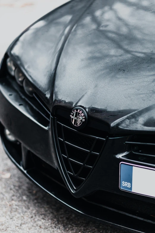 the front bumper of a black car that is close to the pavement