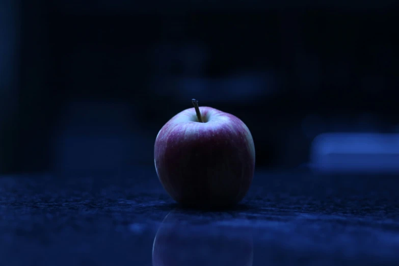 an apple on the ground in a dark room