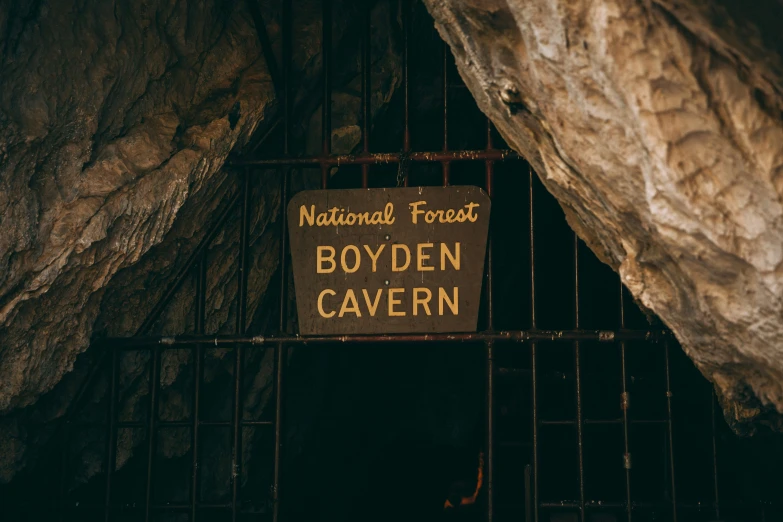 sign posted on metal gate in an underground cave