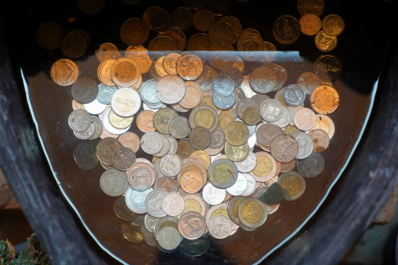 a group of coins inside of a vase on top of a table