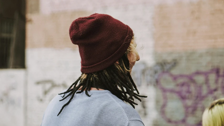 a man with dreadlocks wearing a red hat