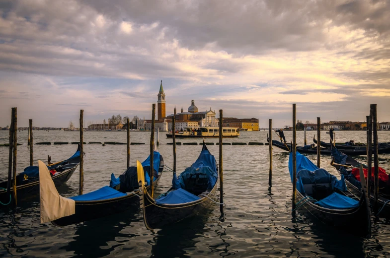 several boats sitting on the dock with buildings in the background