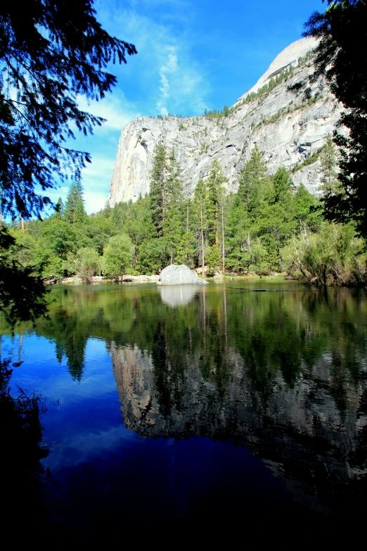 a lake surrounded by trees in front of a mountain