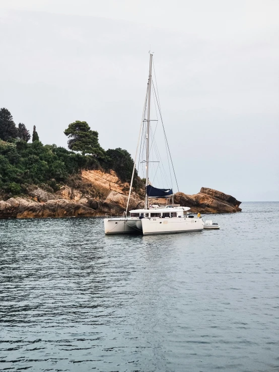 a sailboat in the water near a rock