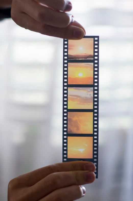 someone holding a film strip with a picture of the sun