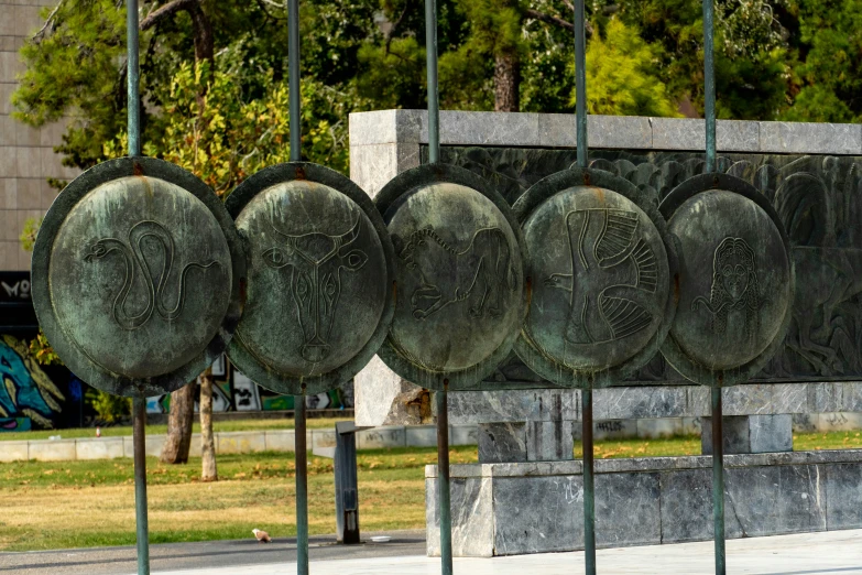 five metal objects with a long stand in front of a tree