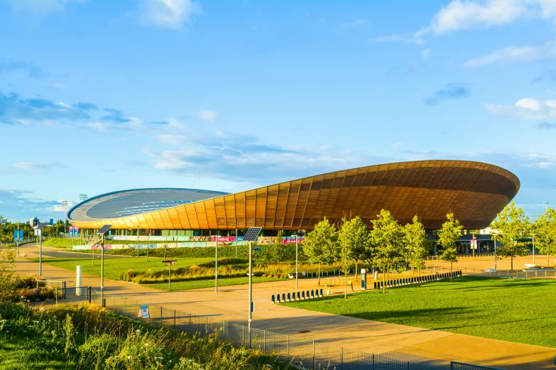 the exterior of a building sits on a grassy lot near a park