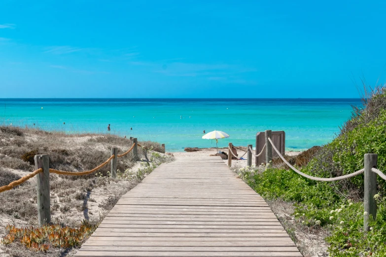 the path to the beach leads to an umbrella