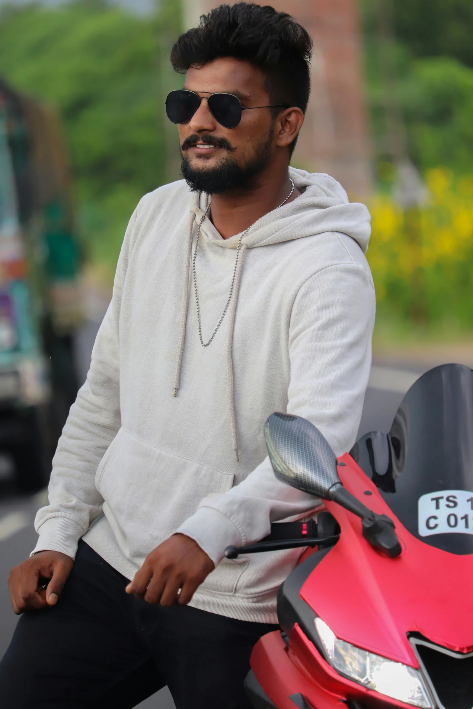 the man is sitting on a motorcycle wearing sunglasses