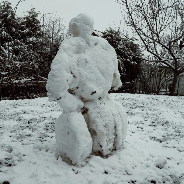 a snow man is sitting on top of a pile of snow