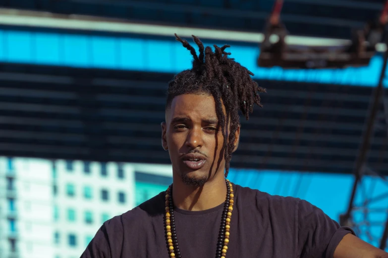 a man with dreads standing in front of a building