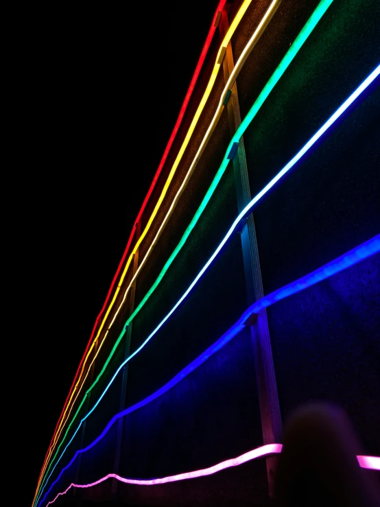 rainbow colored lights are projected on a large building