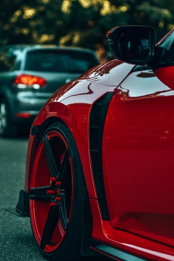 a red sports car sits parked in the parking lot